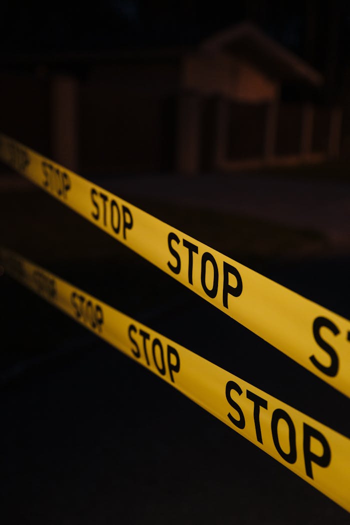 Yellow stop tape in a night crime scene setup, creating a tense atmosphere.